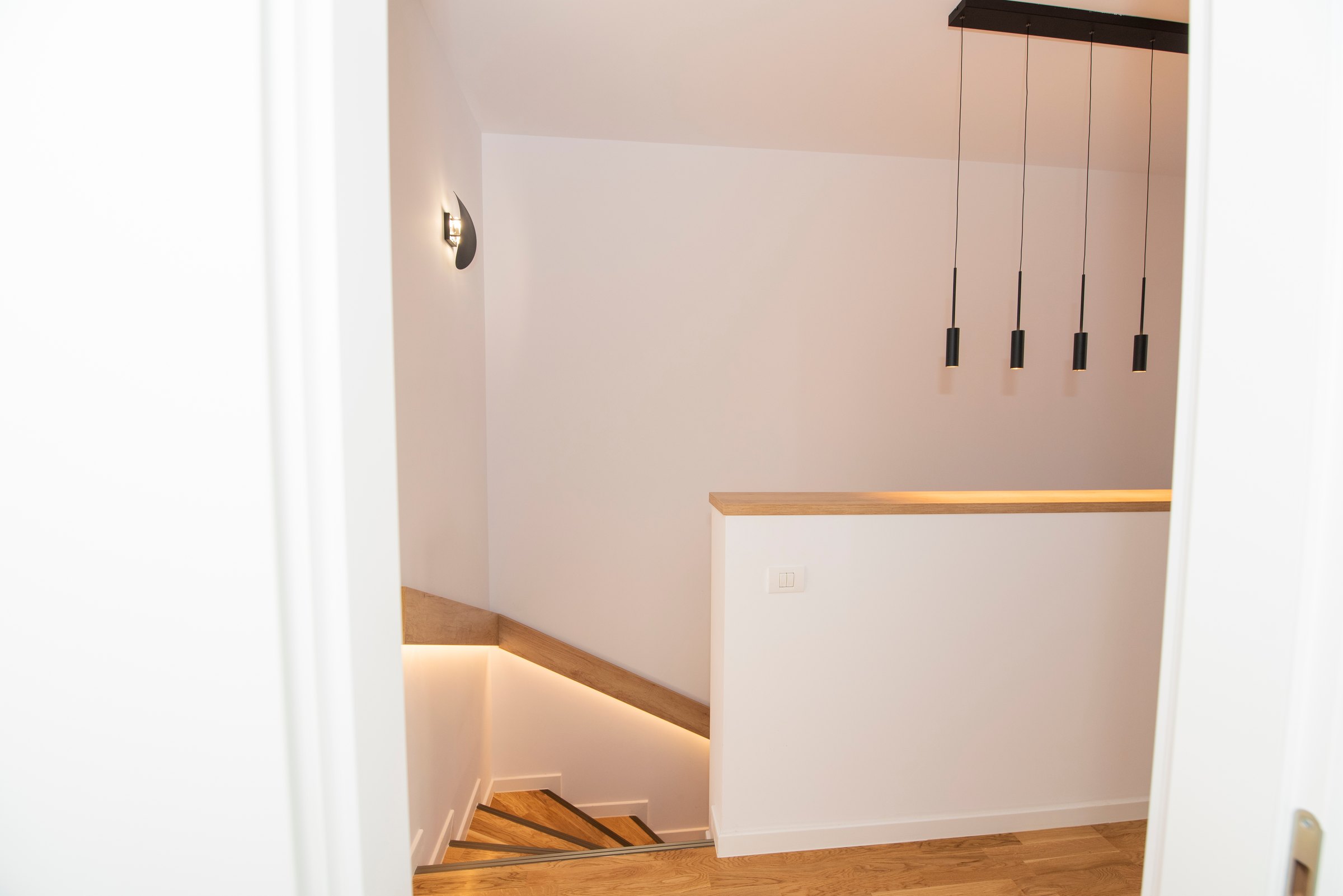 Casa scării văzută de sus, cu parapet alb și poliță în decor de stejar