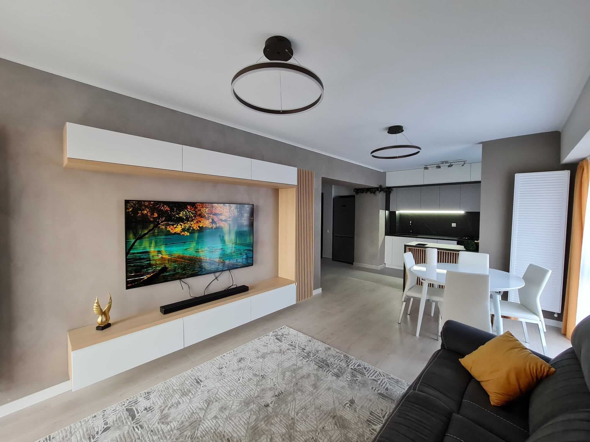 Living cu perete TV alb, ramă din stejar și lamele verticale